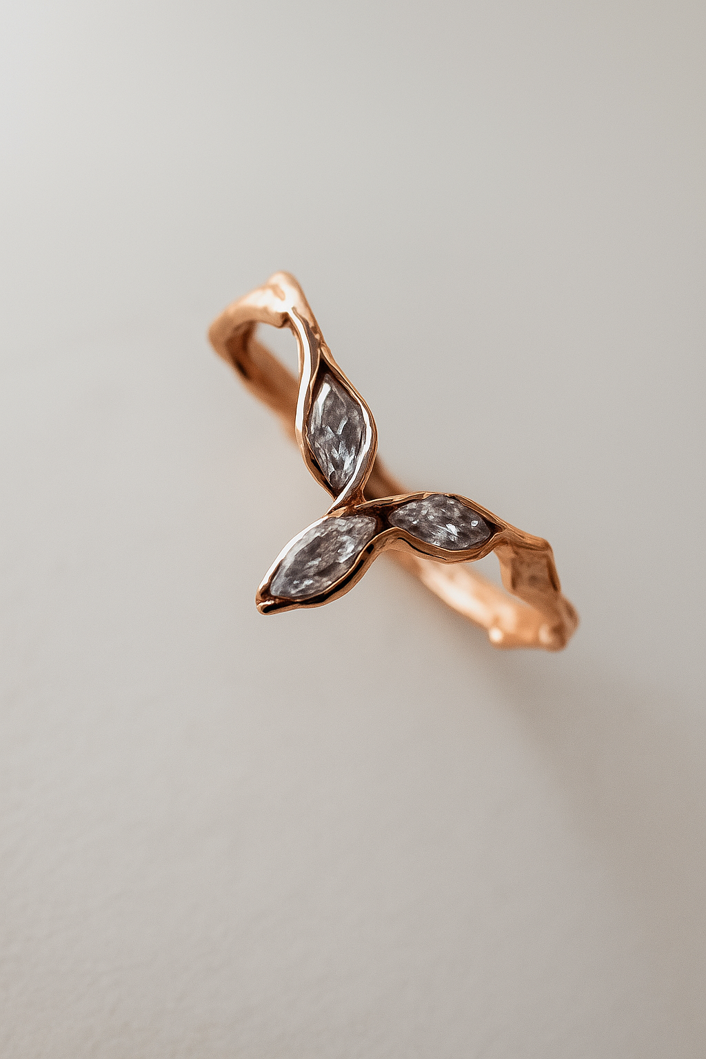 Angled side shot of the rose gold Marqueza ring, showing its delicate zircon stones and sculptural band.