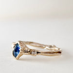 Angled side view of the 10k yellow gold ring highlighting the Montana sapphire and lab-grown diamonds along the textured band.