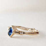 Angled side view of the 10k yellow gold ring highlighting the Montana sapphire and lab-grown diamonds along the textured band.