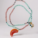“Flat lay of Orange Necklace on a white background, showing alternating mint‑green and pink beads with a bright orange crescent pendant.