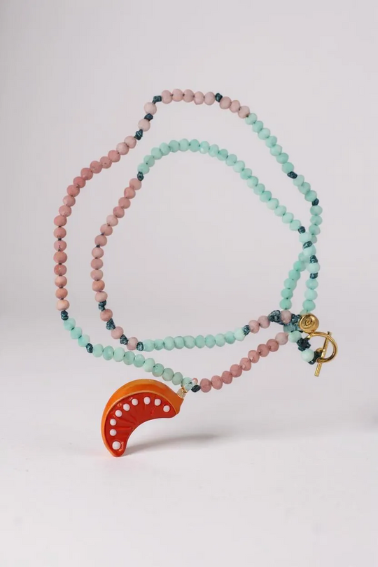 “Flat lay of Orange Necklace on a white background, showing alternating mint‑green and pink beads with a bright orange crescent pendant.