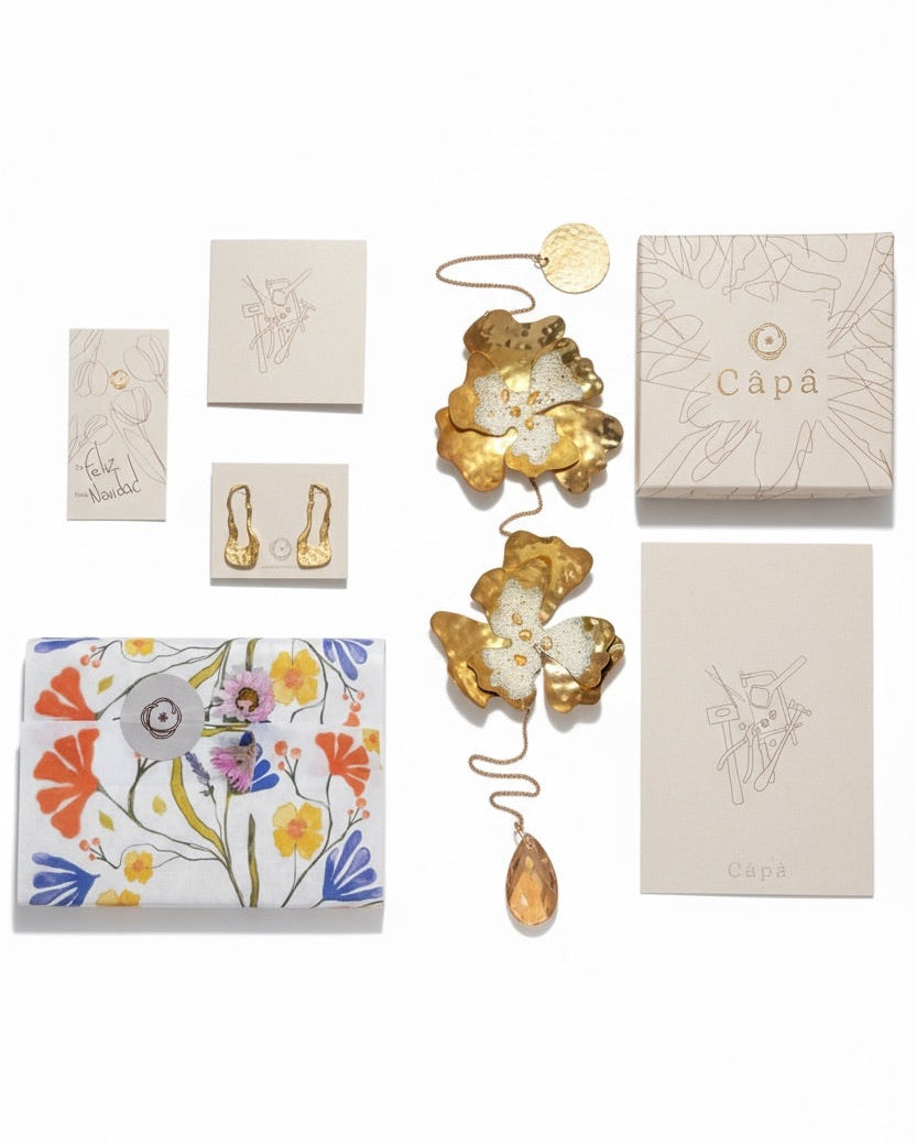 Collection of decorative items including a floral-patterned box, gold butterfly ornament, and 'Capa' branded boxes on a white background.
