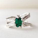 Top-down view of the sterling silver ring featuring a lab-grown emerald and sculpted organic band.