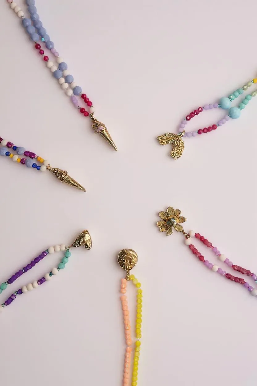 Colorful beaded necklaces with various pendants on a light background