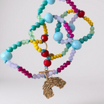 Multicolored crystal bead necklace with a gold rainbow-shaped charm on a white background.