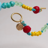 colored bead necklace with gold clasp on a light background.