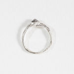 Top view of a silver ring with a hammered band and a raised, irregular stone detail.