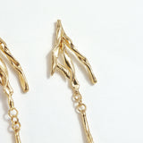Detail of the upper design of the Root Earrings, showing textured golden branches in gold-plated brass.