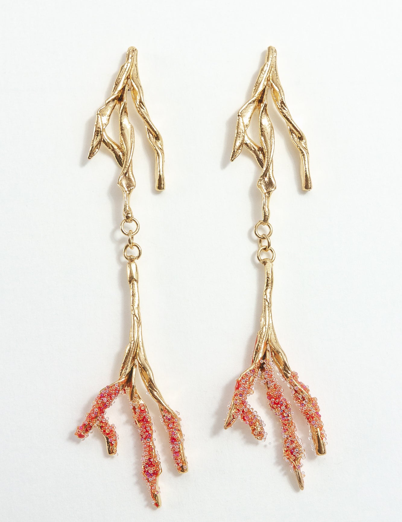 Gold-plated brass Root earrings with textured red tips and glass granulation on a white background.