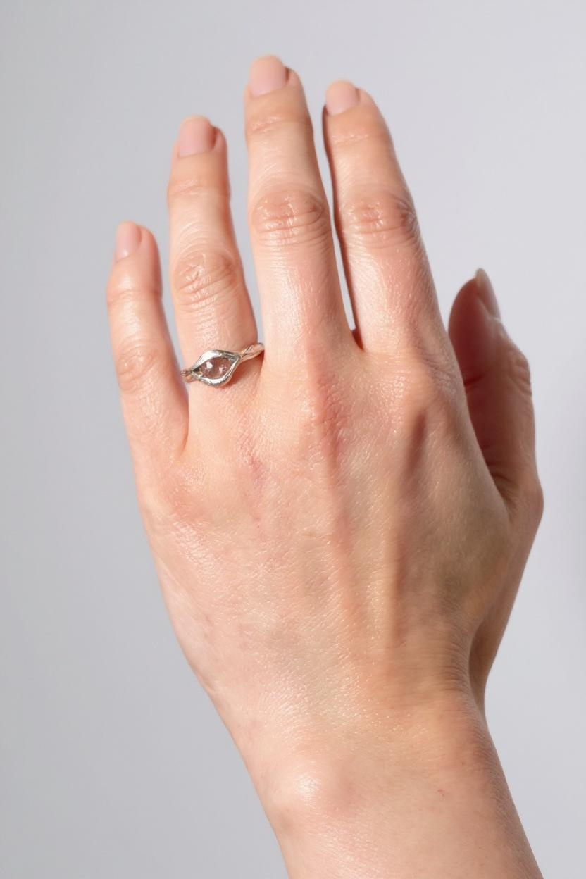 Sterling silver Sunstone ring worn on a hand, photographed against a light grey background.