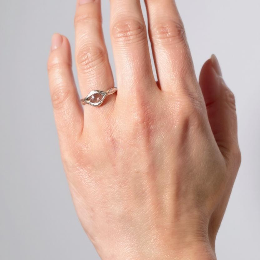 Sterling silver Sunstone ring worn on a hand, photographed against a light grey background.