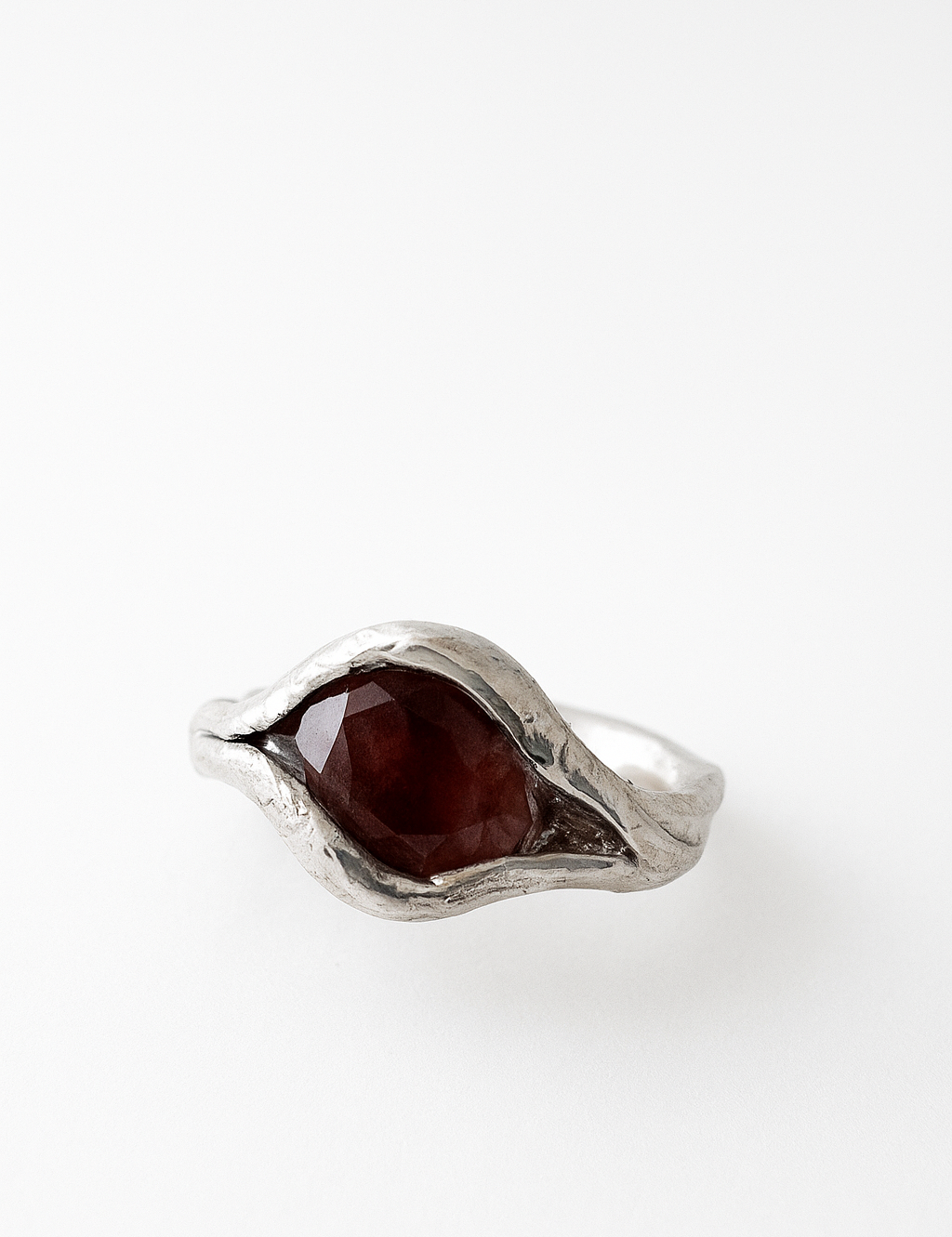 Close-up of the sterling silver ring featuring an oval sunstone set organically in the band, captured from above.