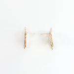 Side view of the red elderberry stud earrings showing the spike and volume of the gold-plated brass piece.