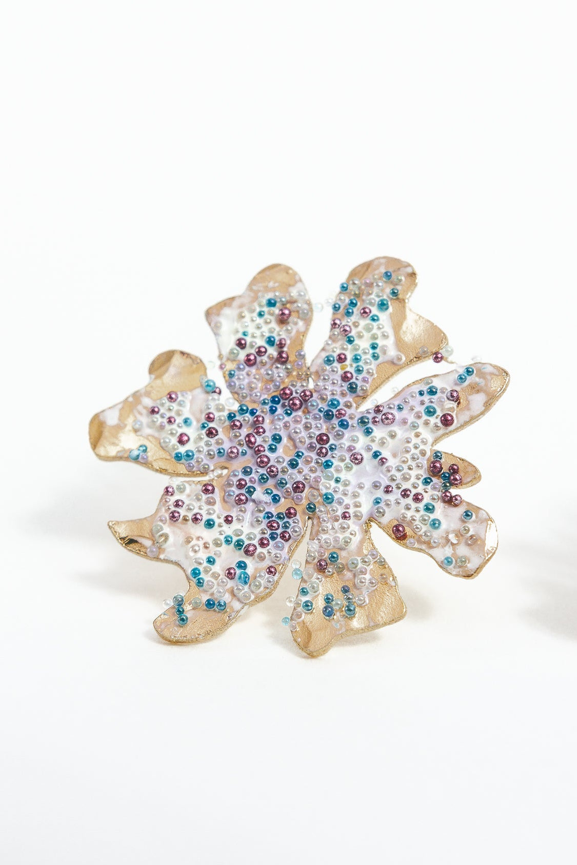 Close-up detail of the Wild Clover stud earrings, showing the textured surface and multicolored glass granulation.