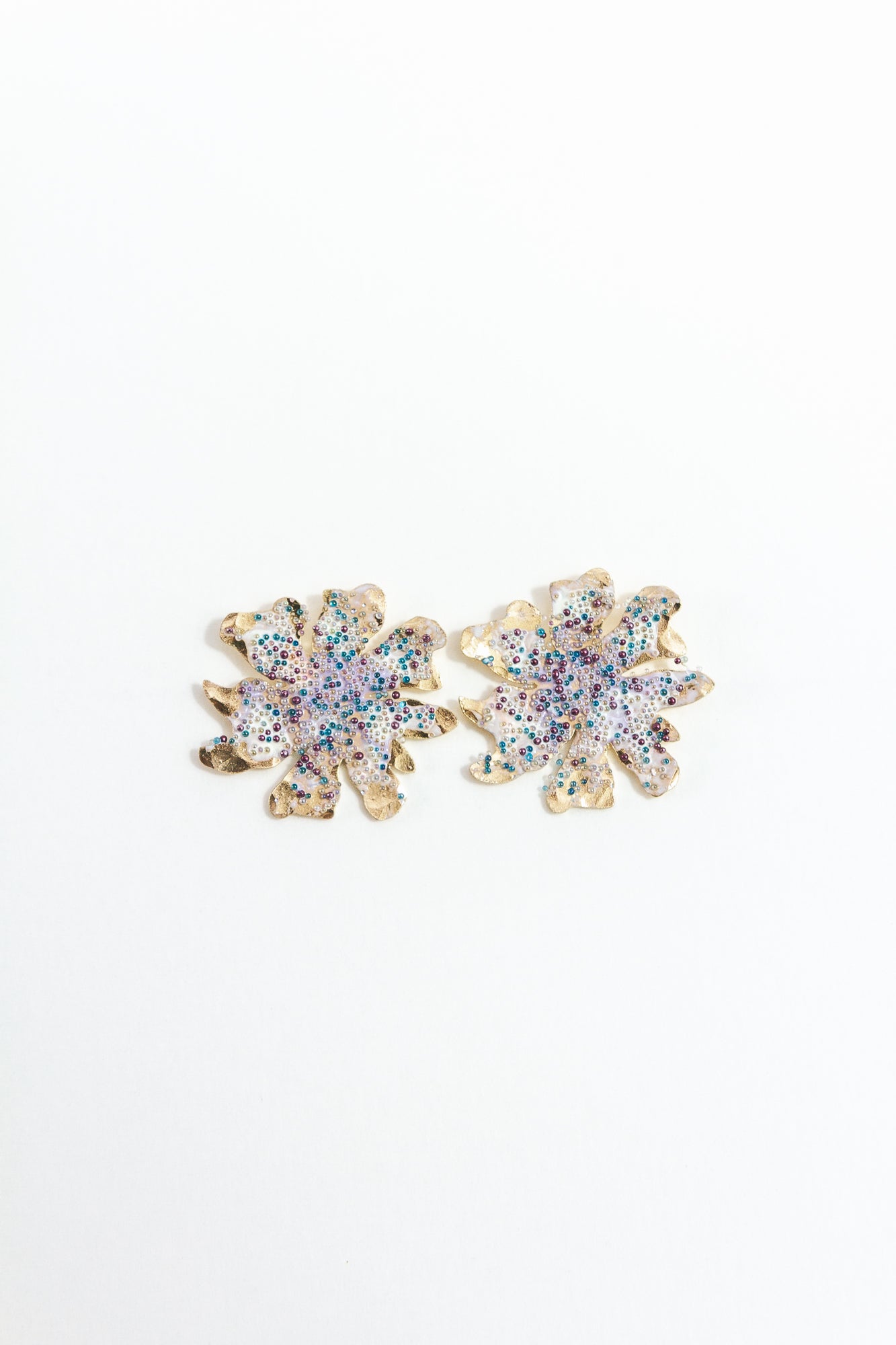 Wild clover stud earrings in gold-plated brass with organic texture and glass granulation in lavender tones on a white background.