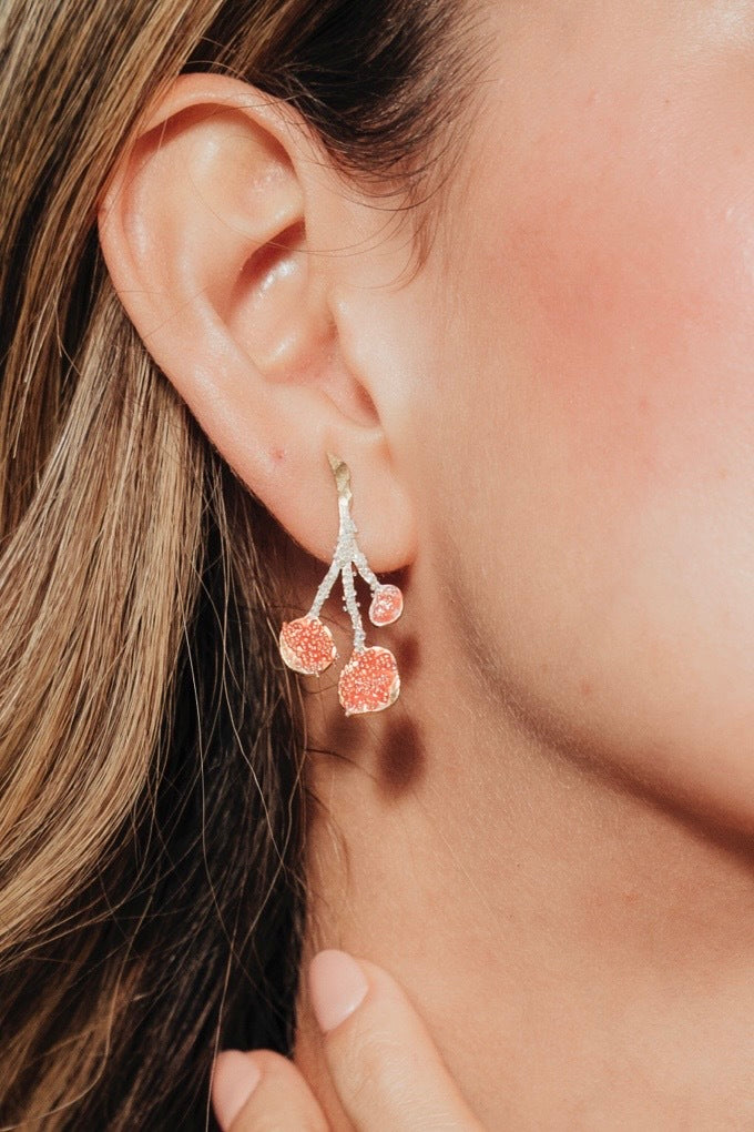 Close-up of the model wearing a agraz Earring, showcasing its botanical design and handcrafted finish.