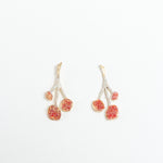 Pair of agraz Earrings presented on a white background, highlighting their design inspired by branches and fruits.