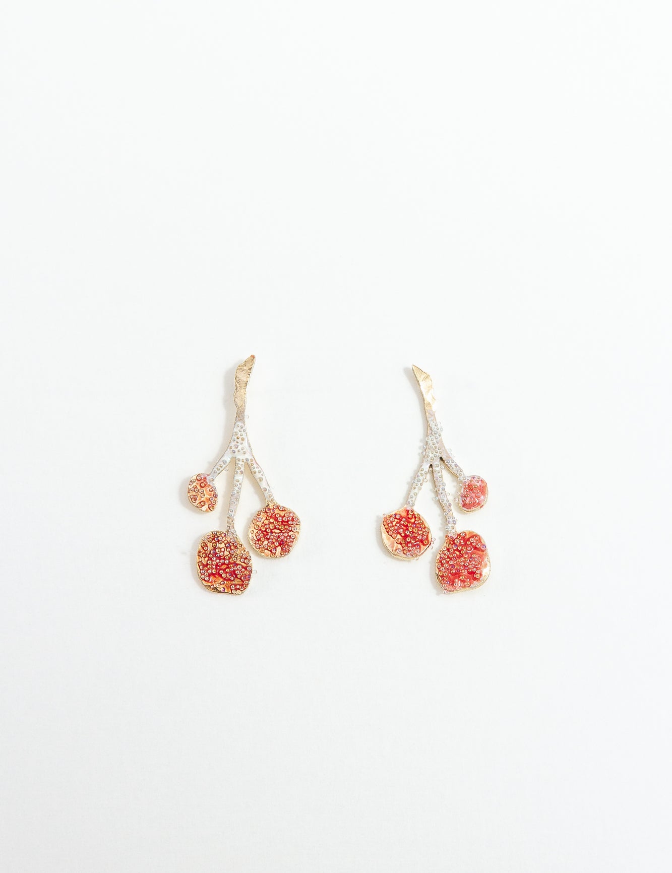 Pair of agraz Earrings presented on a white background, highlighting their design inspired by branches and fruits.