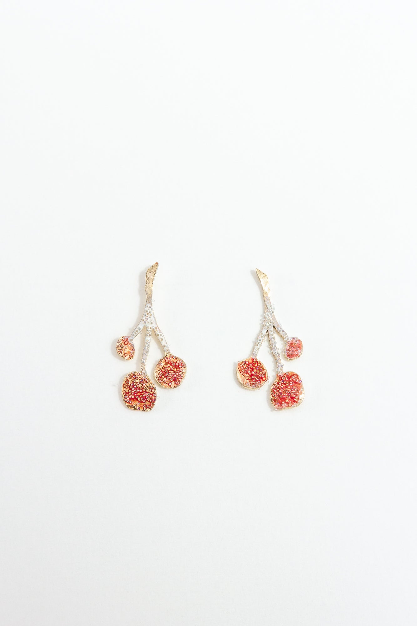 Pair of agraz Earrings presented on a white background, highlighting their design inspired by branches and fruits.