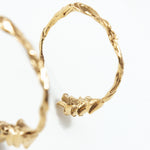 Macro detail of the gold Espiga hoop earrings, showing handcrafted texture and gold-plated finish.