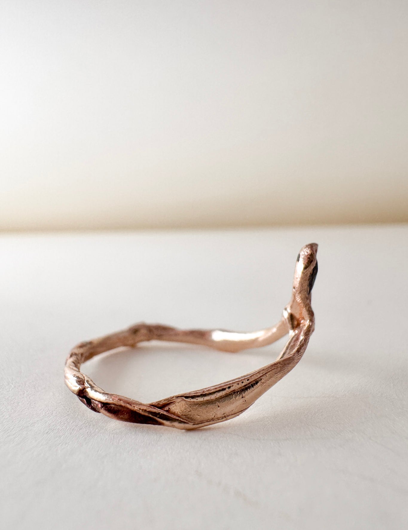 Side view of the 14k rose gold ring featuring a salt-and-pepper diamond, highlighting the asymmetrical sculpted band.