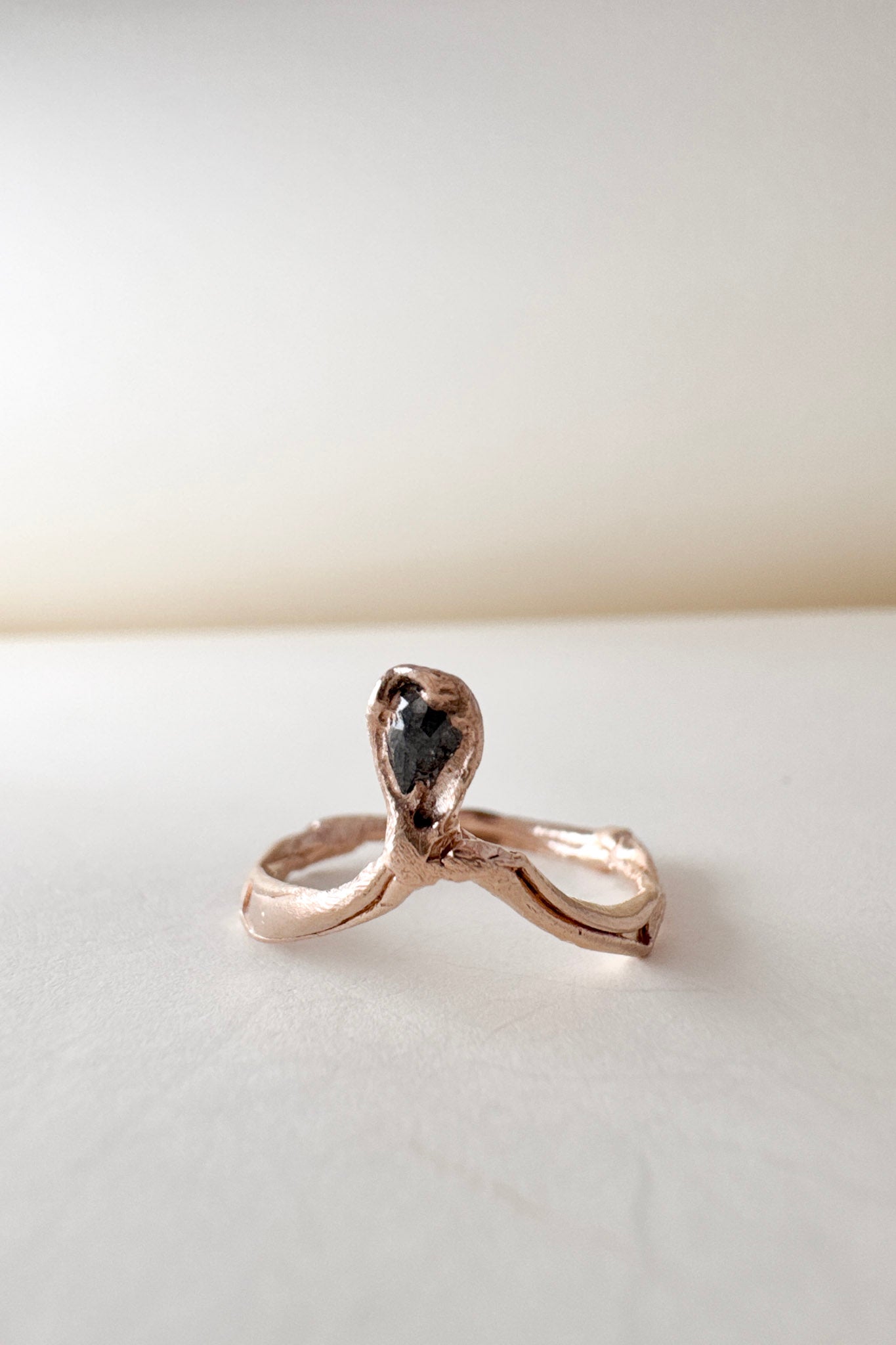 Angled close-up of the salt-and-pepper diamond set in a 14k rose gold ring, emphasizing the rustic texture and sparkle.