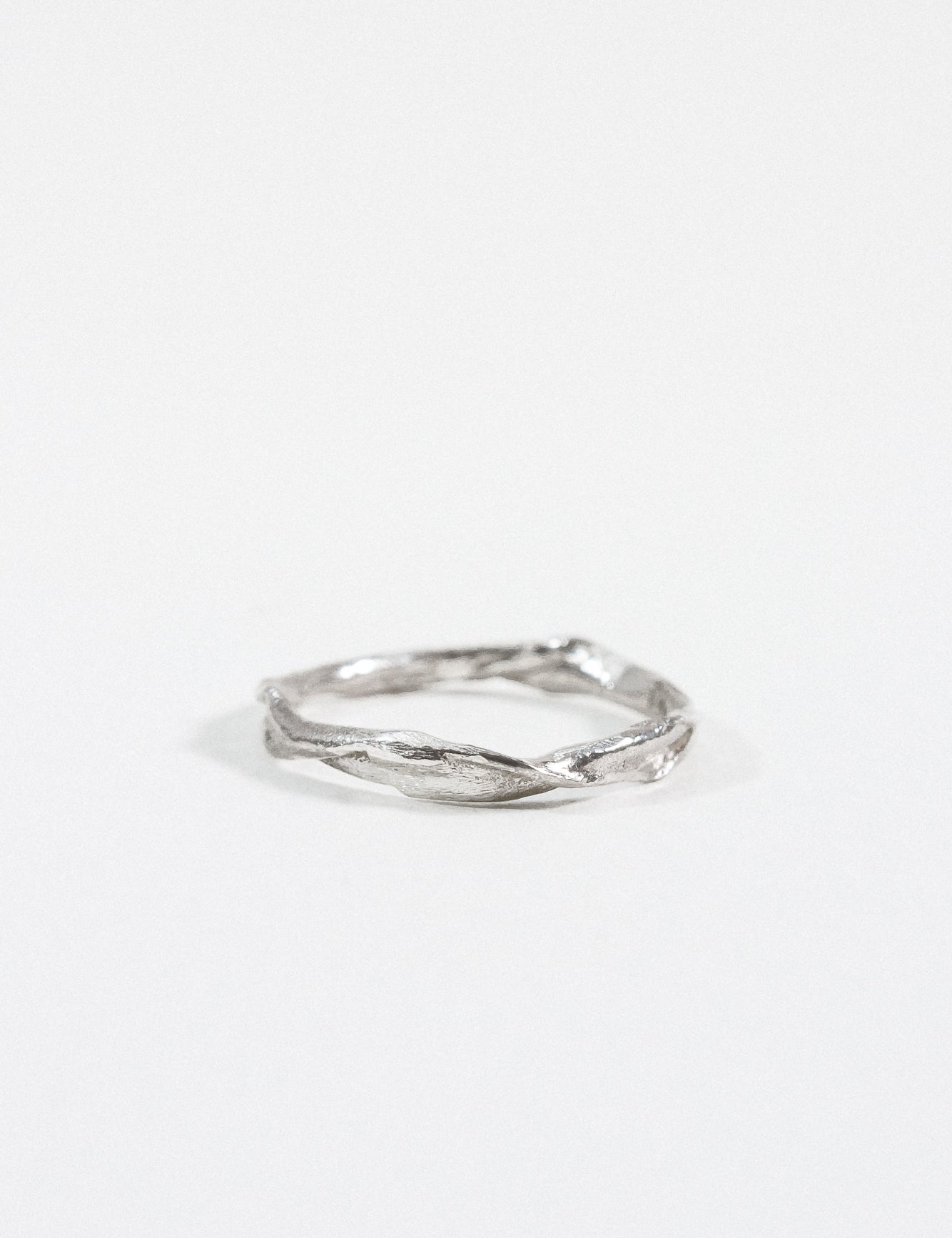 Sterling silver Nest Ring with a small lab-grown diamond inset in a twisted organic band, shown on a white background.