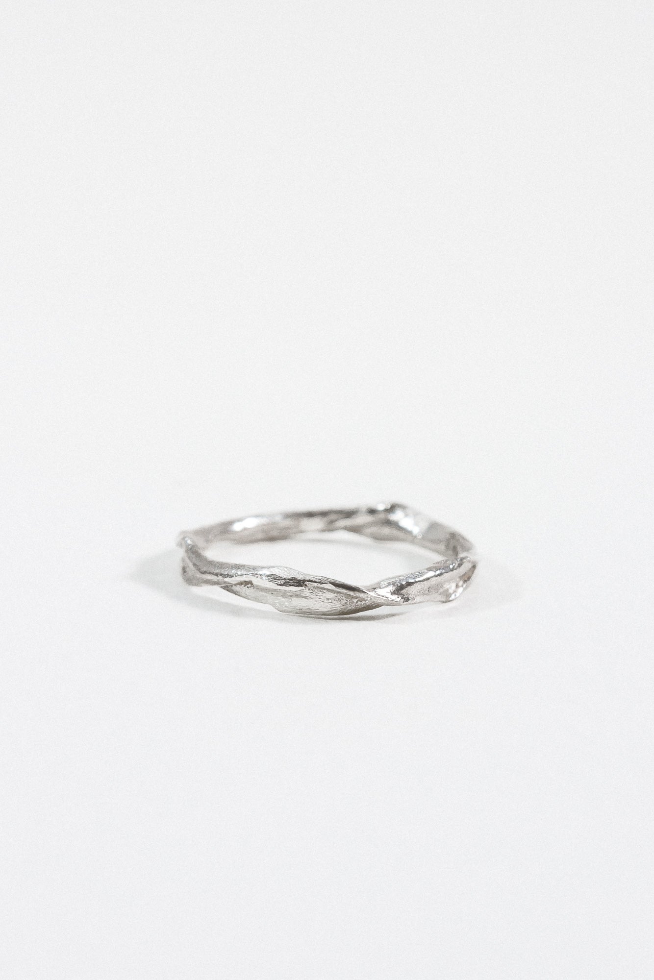 Sterling silver Nest Ring with a small lab-grown diamond inset in a twisted organic band, shown on a white background.