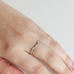 Nest Ring in sterling silver with a lab-grown diamond worn on a hand, photographed over a soft neutral surface.