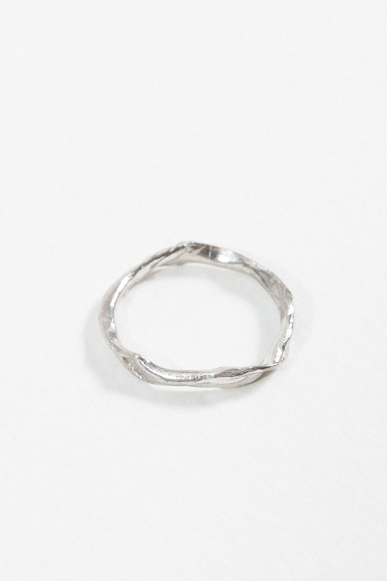 Top view of the sterling silver Nest Ring showing the small inset lab diamond and organic circular shape.