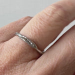 Artisan silver ring with lab-grown diamonds worn on a finger, captured from a side angle.