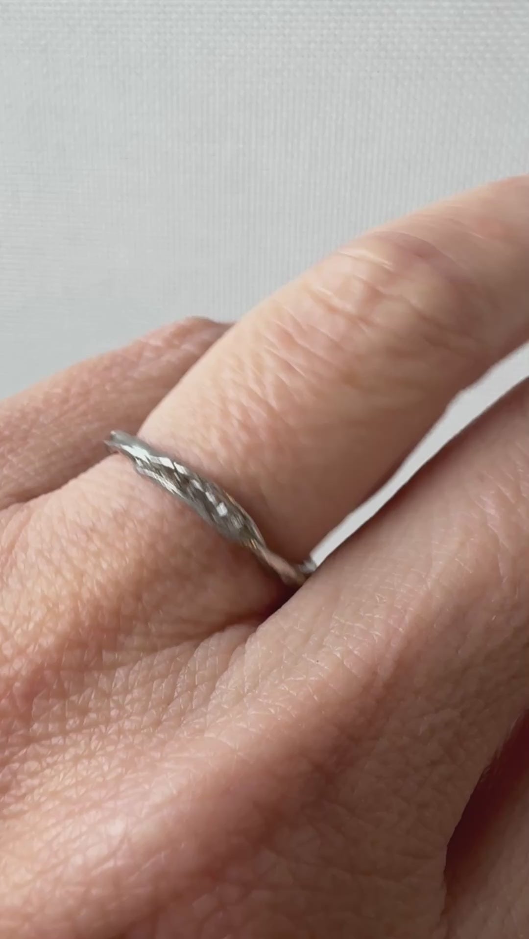 Artisan silver ring with lab-grown diamonds worn on a finger, captured from a side angle.