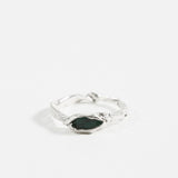 Front view of the sterling silver Refuge Ring showcasing a raw emerald embedded in an organic band, on a white background.