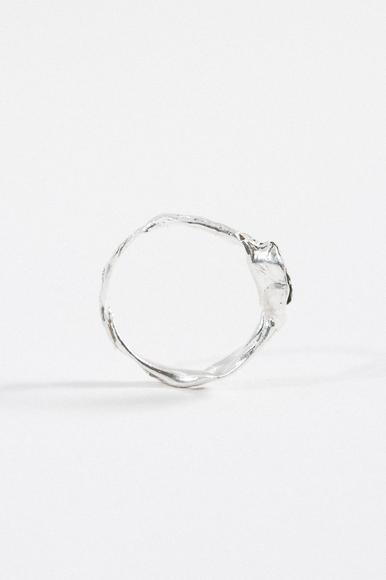 Back view of the sterling silver Refuge Ring highlighting the textured circular band without the gemstone visible.